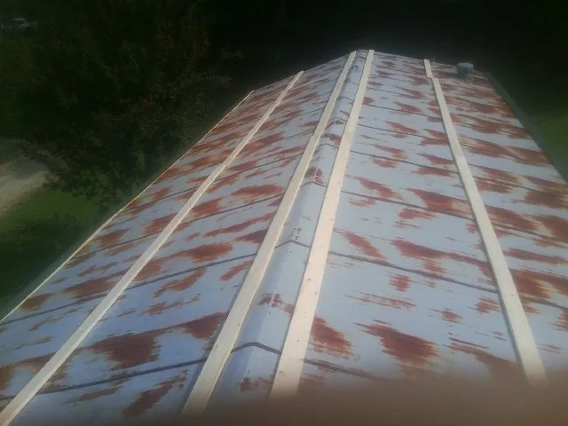 Rusted metal roof panels with new wood purlins before replacement — Storm Damage Roof Repair in West Chester by Roofing Brothers